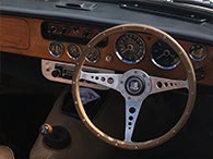 Steering wheel with wooden-panelled dashboard